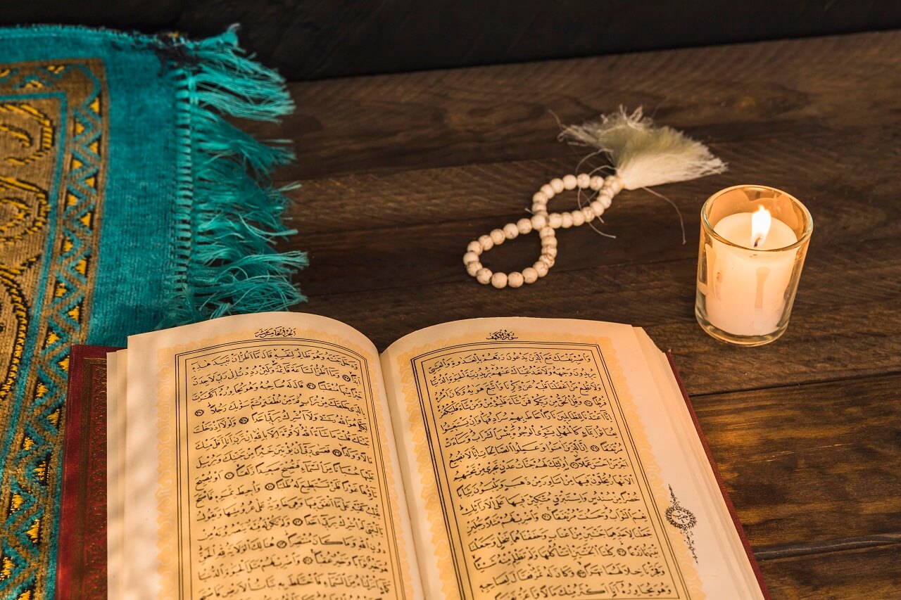 prayer beads candle near religious book (1)